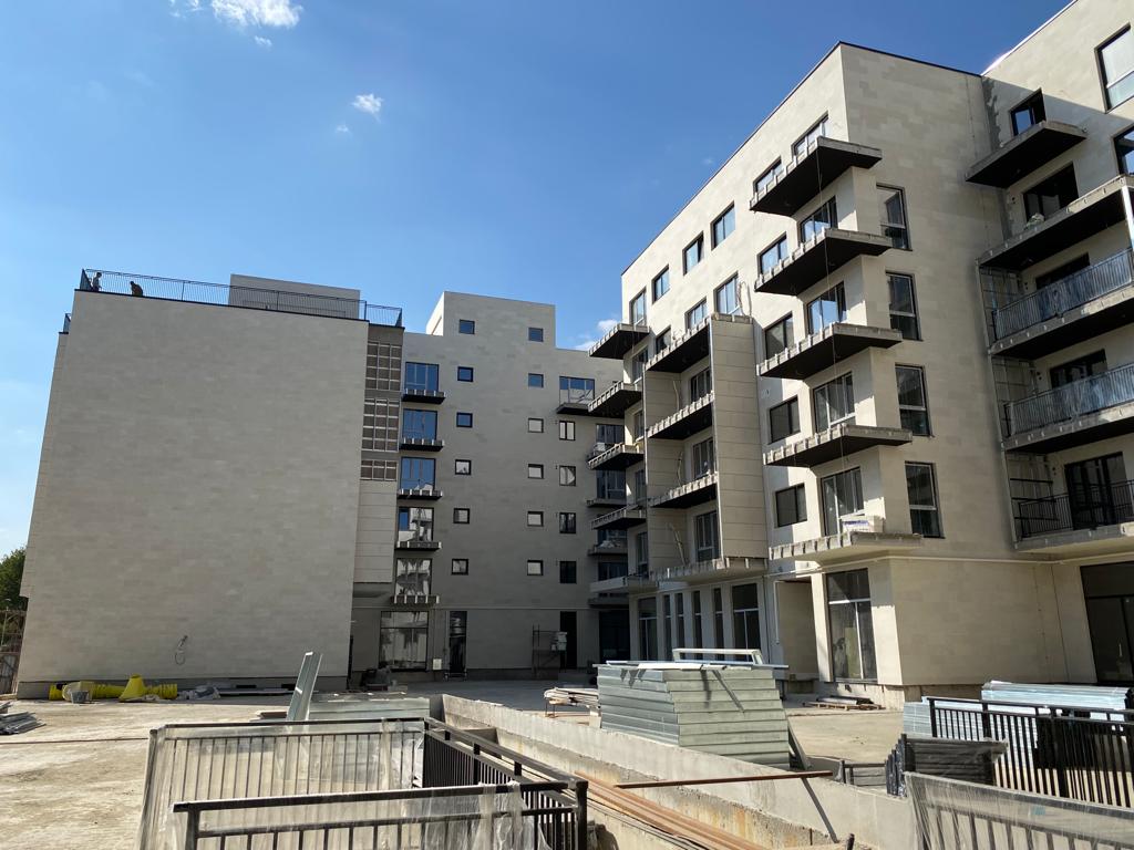 Courtyard between the blocks, with a beige gable wall on the left and site containers