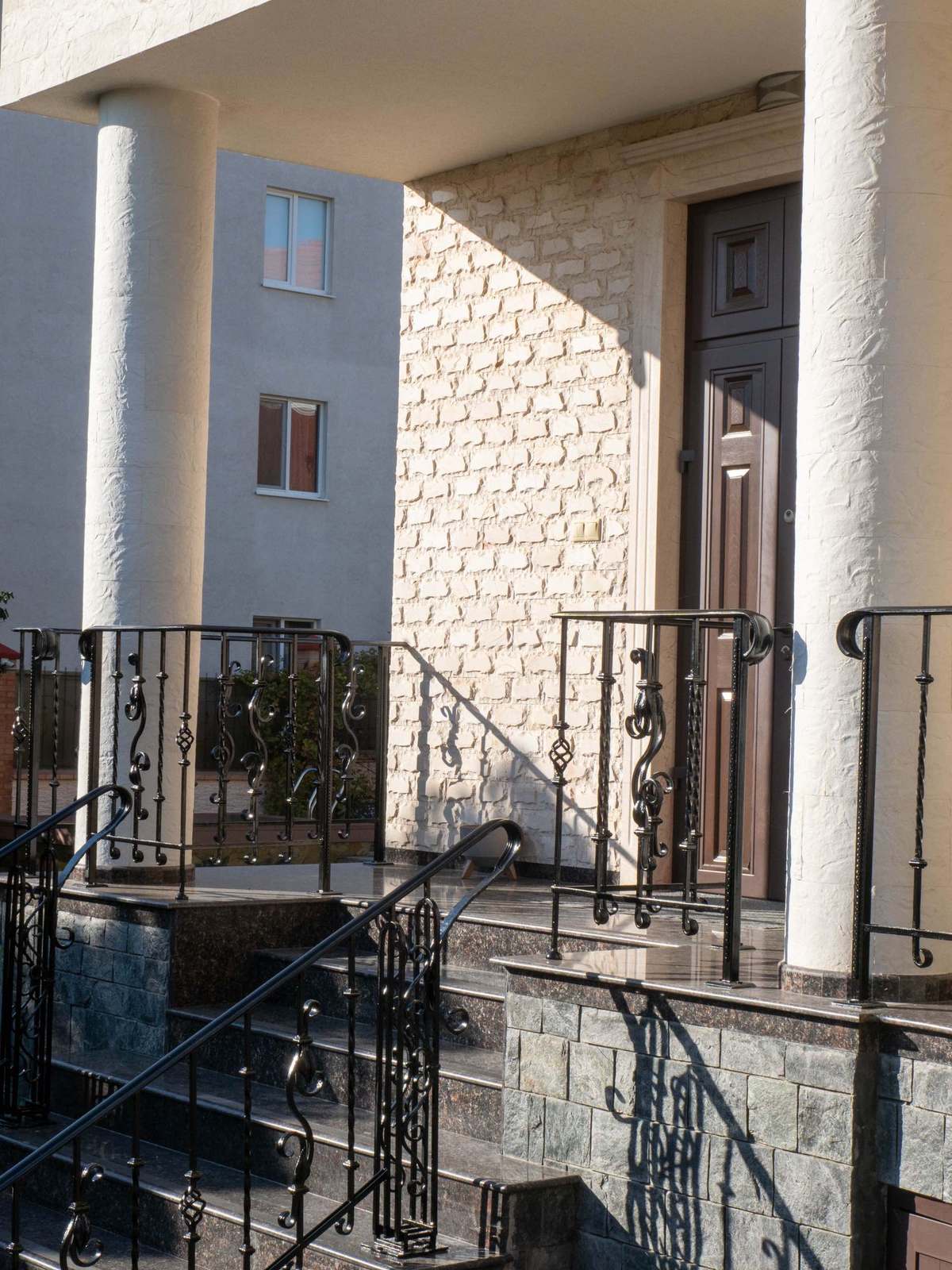 Round column by the entrance, clad in flexible stone along its full radius