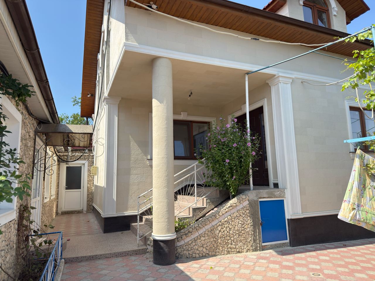 Round entrance column clad in flexible stone bent to a radius