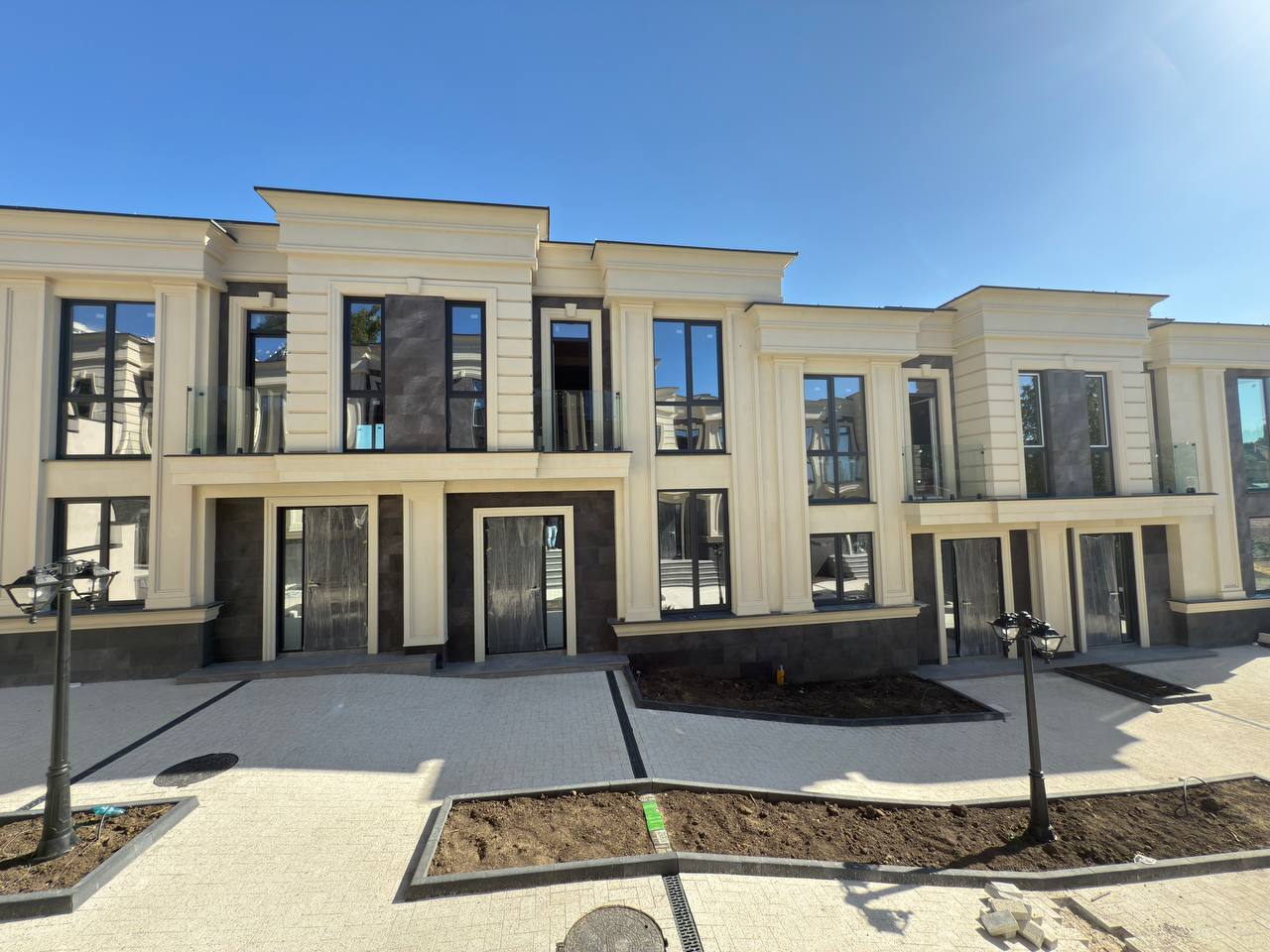 Main facade of the complex: two registers of flexible stone, pilasters and glass balustrades