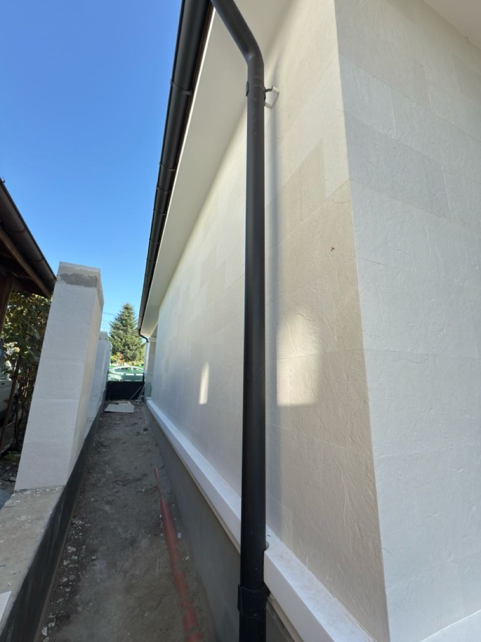 Side passage along the flexible stone wall, with a fence, in perspective