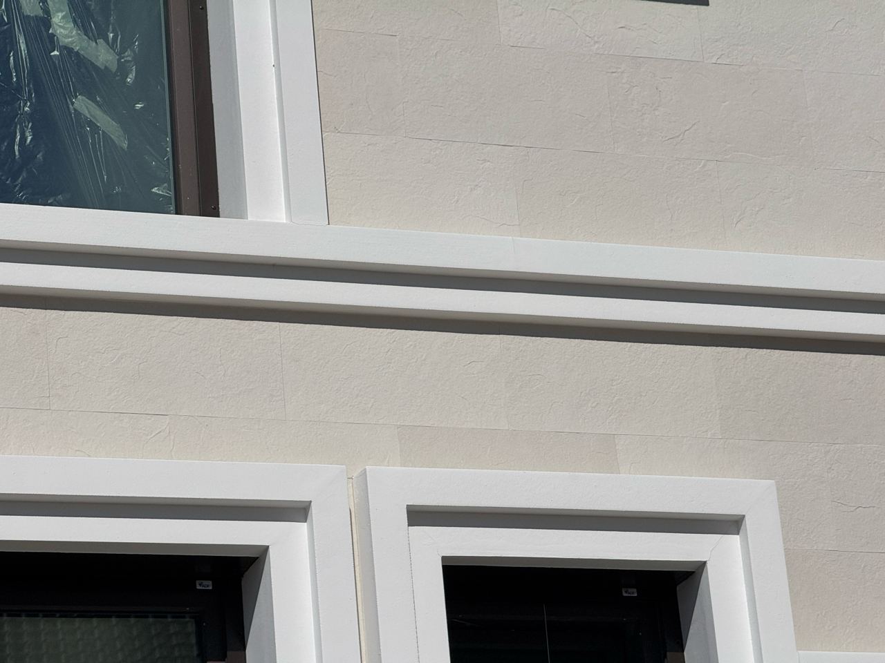 Bands of flexible stone between the white cornices between levels, seen from below